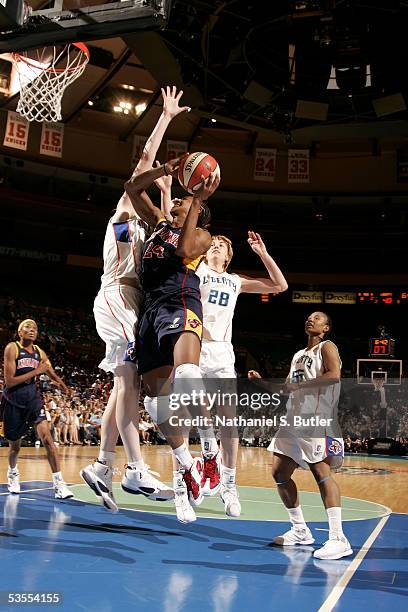 Tamika Catchings of the Indiana Fever drives against Cathrine Kraayeveld of the New York Liberty in Game One of the Eastern Conference Semis during...