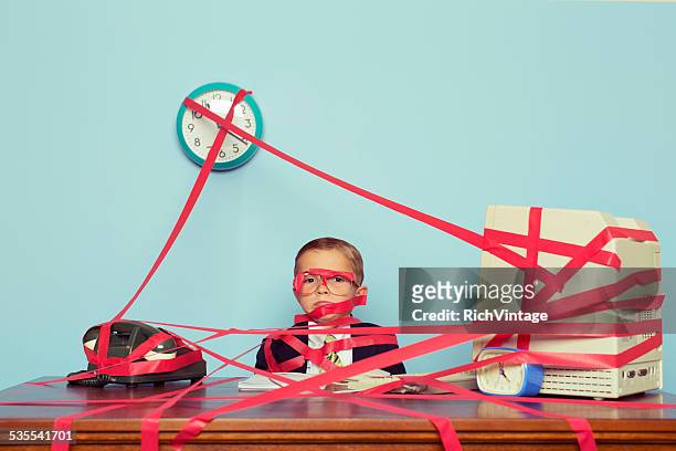 young boy in business office is covered in red tape - ingewikkeldheid stockfoto's en -beelden