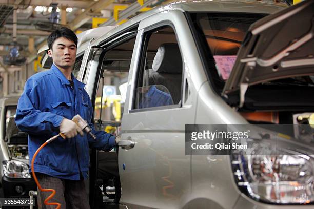 Workers operate on the assembly line at the SAIC-GM Wuling-Automobile Co. Factory in Liuzhou, China,on 12 March 2010. Wuling's mini-commercial...