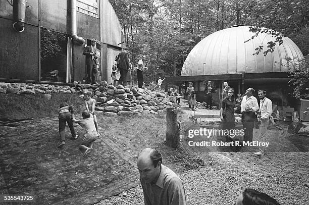 During a visit to Stan Vanderbeek's studio and 'Movie Drome' theatre as part of the New York Film Festival, attendees talk amongst themselves as...