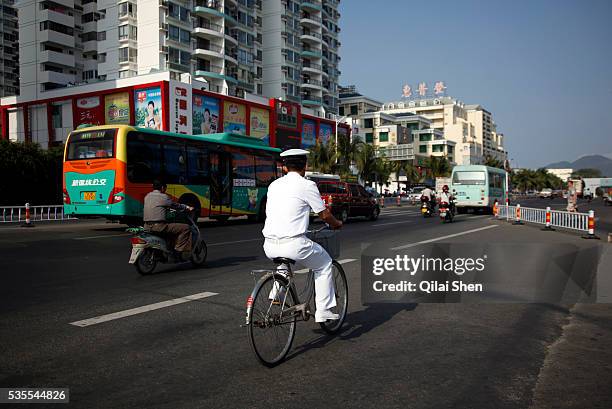 Chinese Peoples Liberation Army naval officer rides his bicycle down a street in Sanya, Hainan Province, China on 14 April 2011. At the southern most...