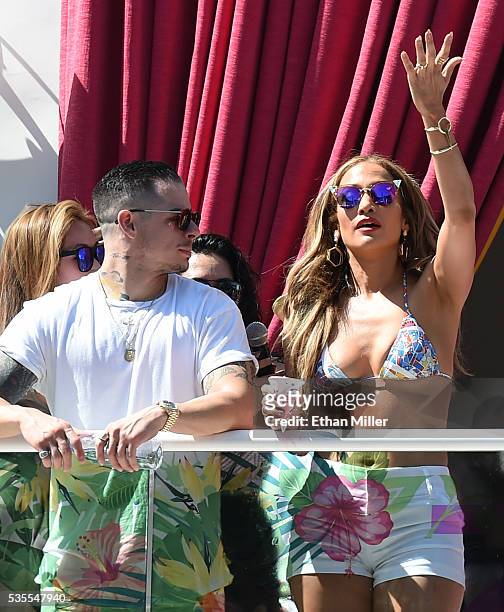 Choreographer/dancer Beau "Casper" Smart looks on as singer/actress Jennifer Lopez gestures to guests while hosting the "Carnival Del Sol" pool party...