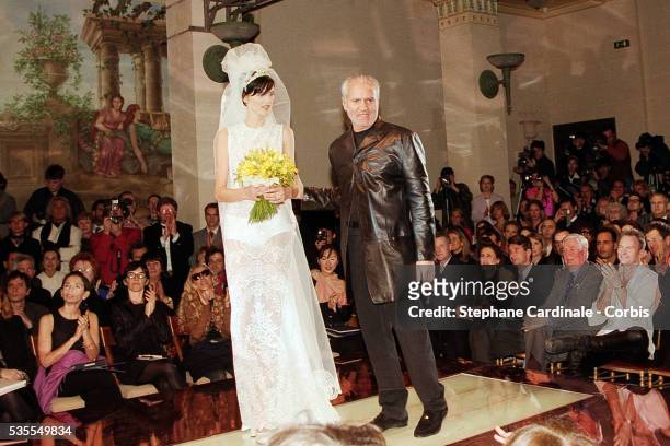 Fashion designer Gianni Versace and model Stella Tennant walk the runway in front of Sting during the Versace Haute Couture Spring/Summer 1996 show...