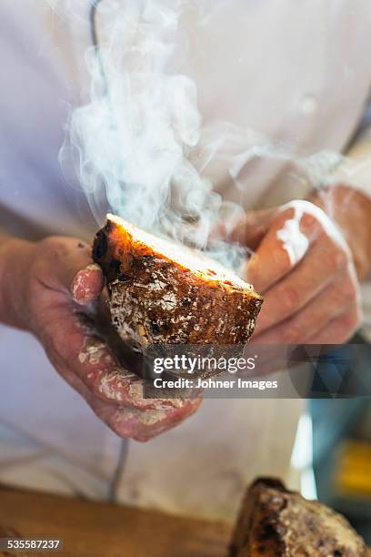 hands holding freshly-baked bread - frische stock-fotos und bilder