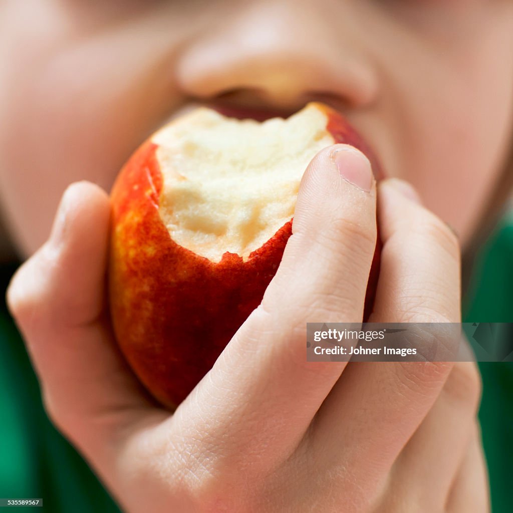 Boy eating apple, close-up