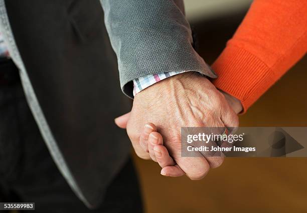 close-up of holding hands - holding hands close up stock-fotos und bilder