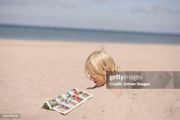 boy on beach reading comic book - svensk sommar bildbanksfoton och bilder