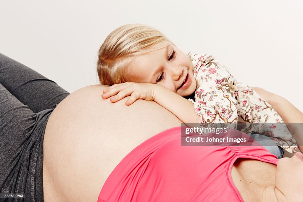Girl with her pregnant mother, studio shot