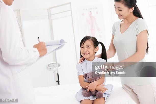 doctor with girl and her mother - talent screening introduction stock-fotos und bilder