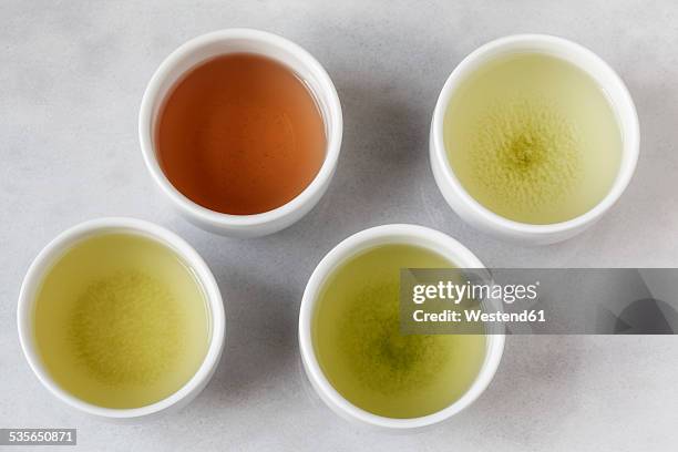 four tea bowls of sencha, gyukuro, hojicha und genmaicha - japanese tea cup stock pictures, royalty-free photos & images