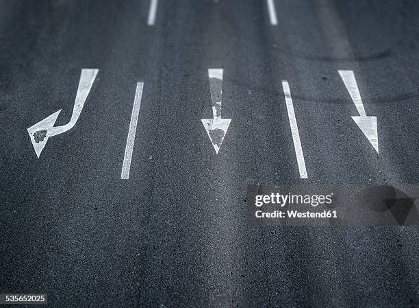 arrow signs on a road - straßenmarkierung stock-fotos und bilder
