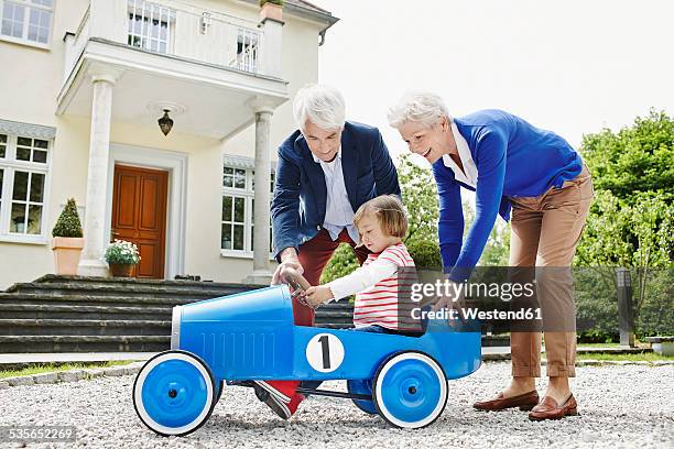 germany, hesse, frankfurt, senior couple with granddaughter sitting pedal car - pedal cars for adults stock pictures, royalty-free photos & images