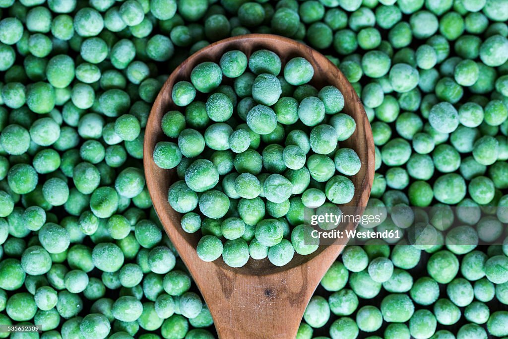 Wooden spoon and frozen peas