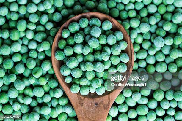 wooden spoon and frozen peas - frozen food - fotografias e filmes do acervo