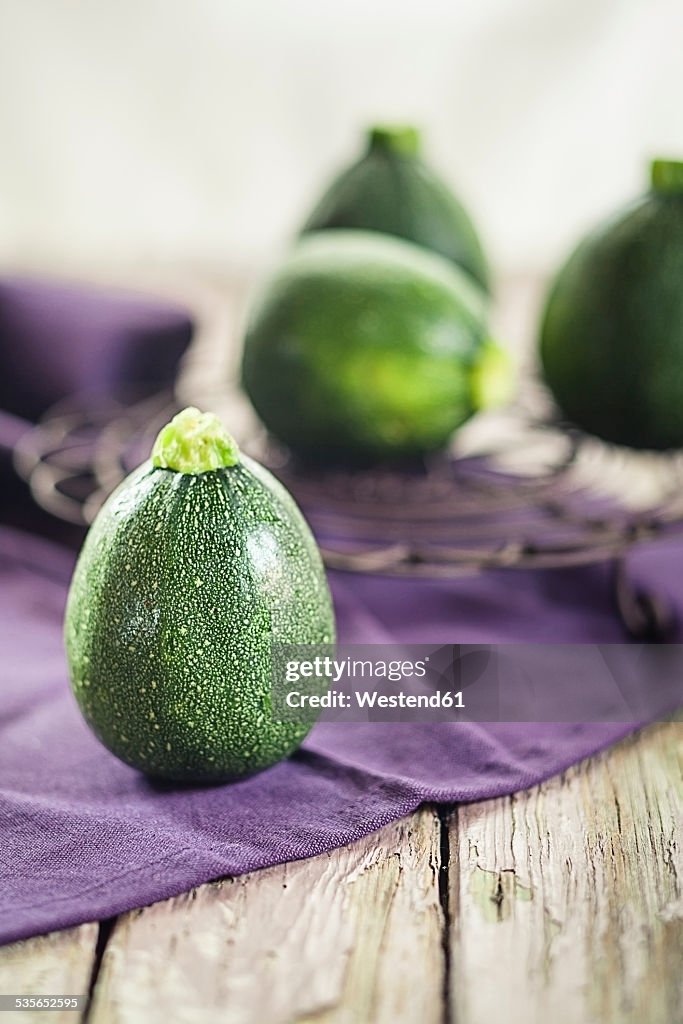 Round courgettes on cloth and wood