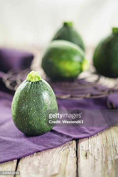 round courgettes on cloth and wood - mergpompoen stockfoto's en -beelden