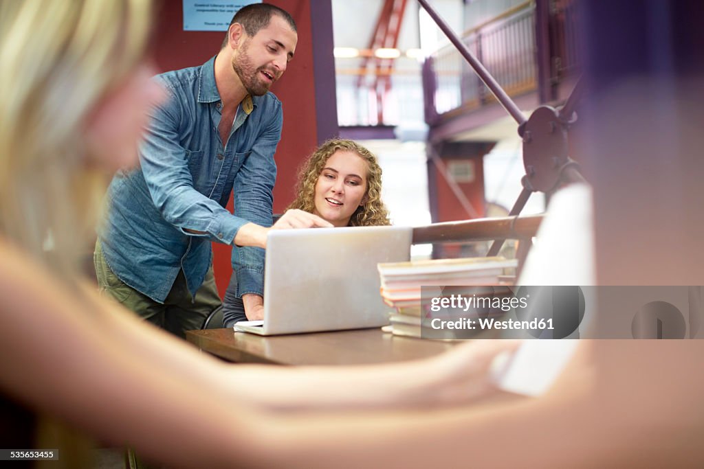 Students using laptop in a library