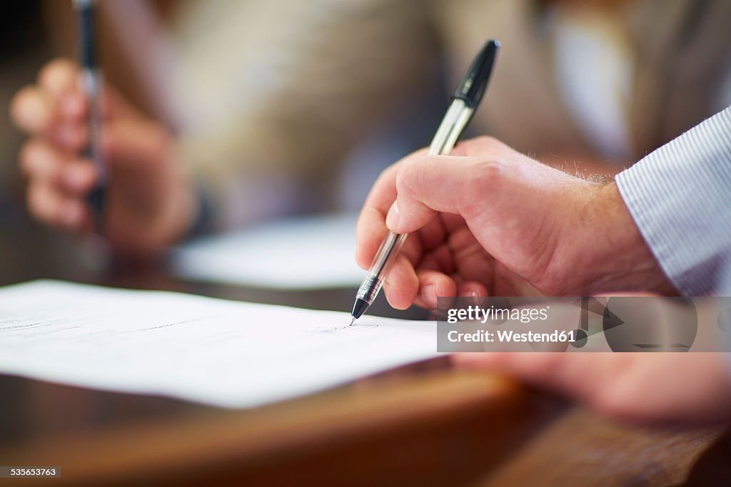 Businessman signing document in boardroom
