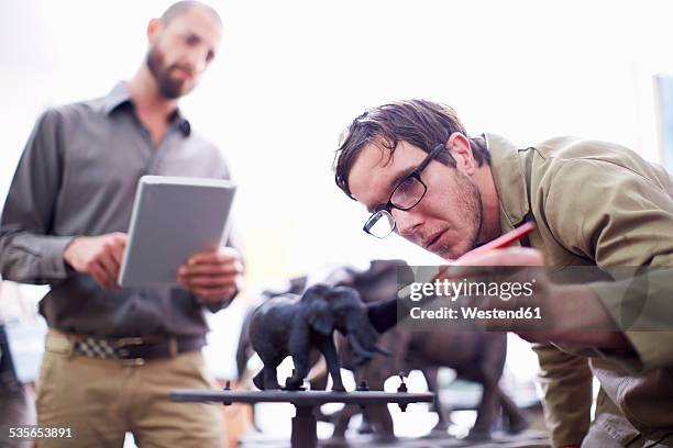 two men with digital tablet in a sculptor's workshop - artists with animals stock pictures, royalty-free photos & images