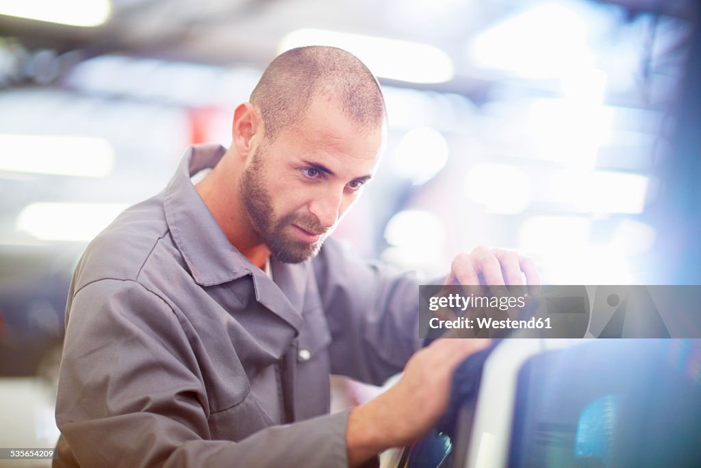 Car mechanic at work in repair garage