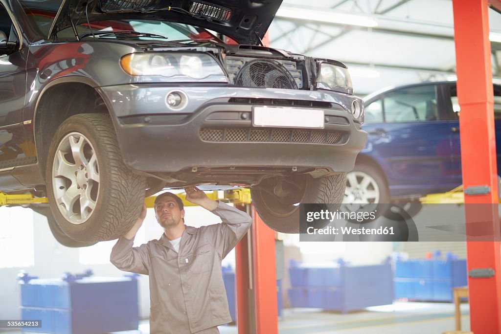 Car mechanic at work in repair garage