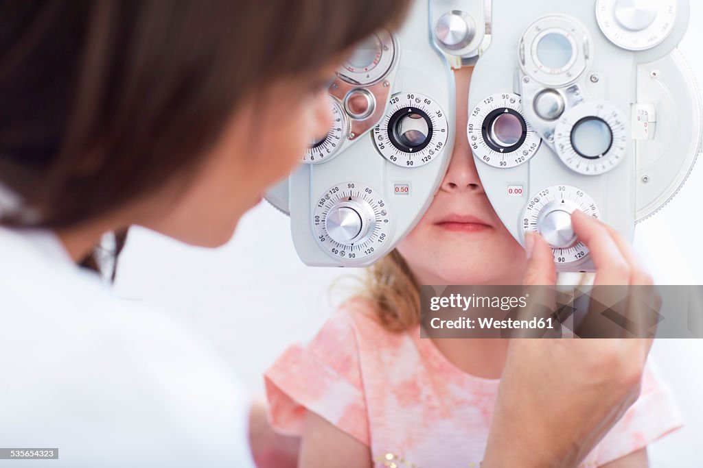 Eye doctor examining girl's vision
