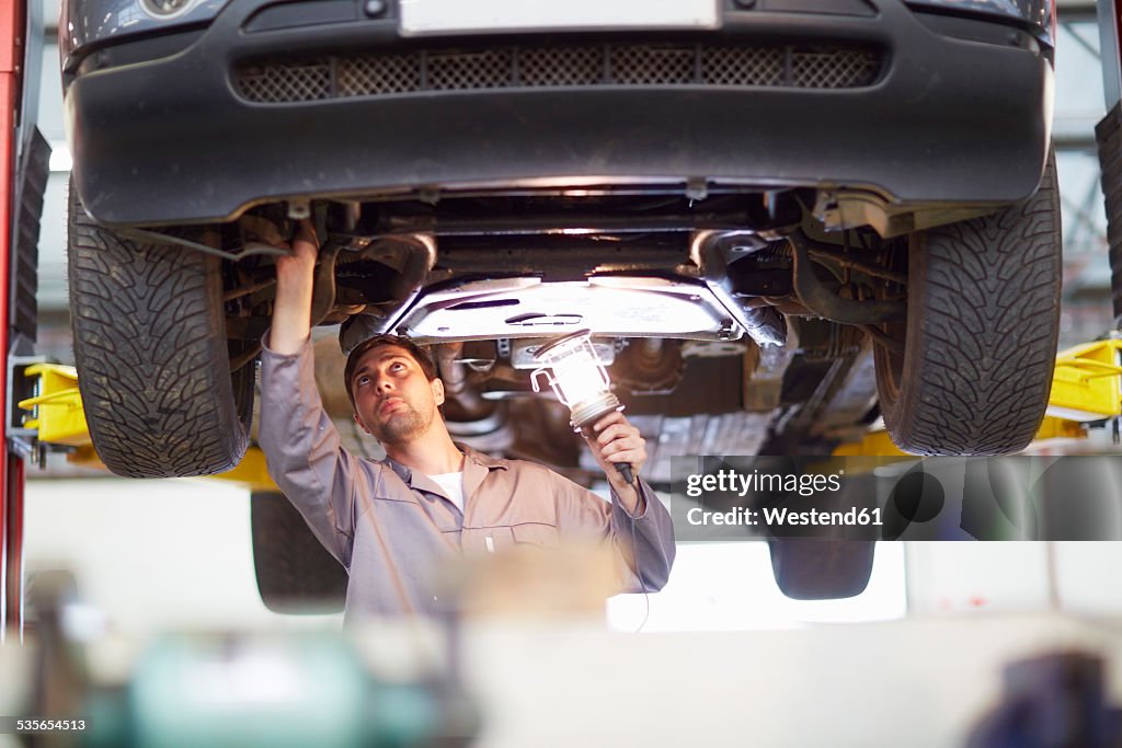 Car mechanic at work in repair garage