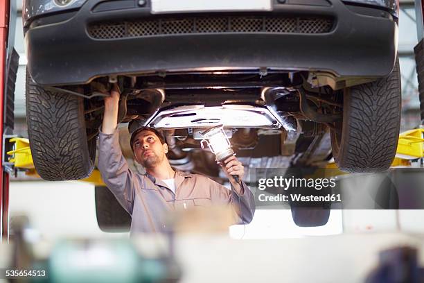 car mechanic at work in repair garage - vaardigheid stockfoto's en -beelden