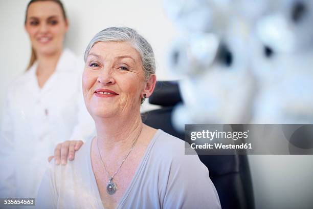 portrait of smiling senior woman at the eye doctor - eye doctor and patient stock pictures, royalty-free photos & images