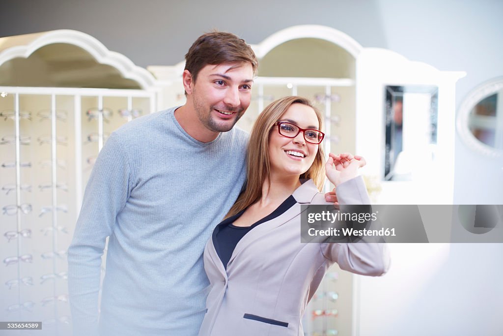 Couple at the optician choosing glasses