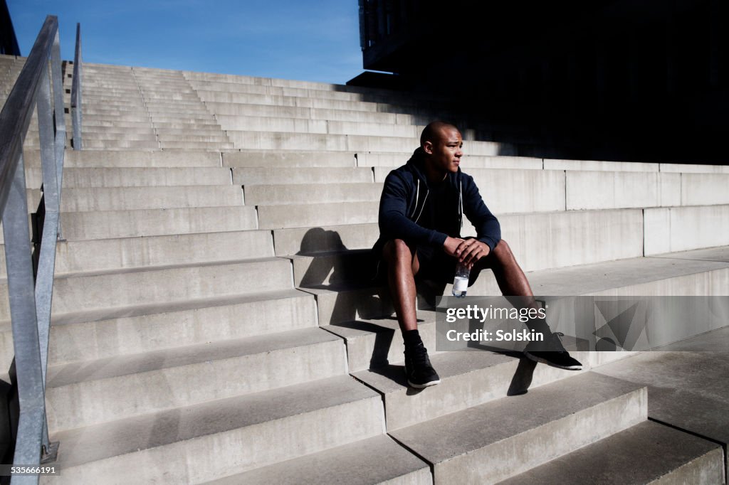 Man resting on outdoor stairs after sport