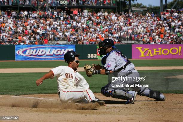 Randy Winn of the San Francisco Giants slides home safely as New York Mets catcher Ramon Castro applies a late tag during the game at SBC Park on...
