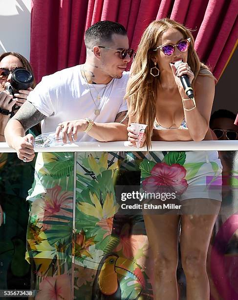 Choreographer/dancer Beau "Casper" Smart looks on as singer/actress Jennifer Lopez talks to the crowd while hosting the "Carnival Del Sol" pool party...