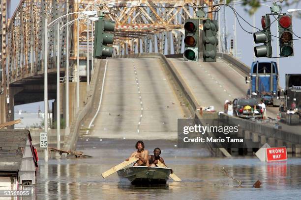 Two men paddle in high water after Hurricane Katrina devastated the area, August 31, 2005 in New Orleans, Louisiana. Devastation is widespread...