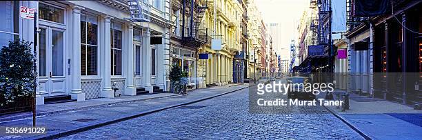 street scene in soho with cast iron buildings - soho new york stock pictures, royalty-free photos & images