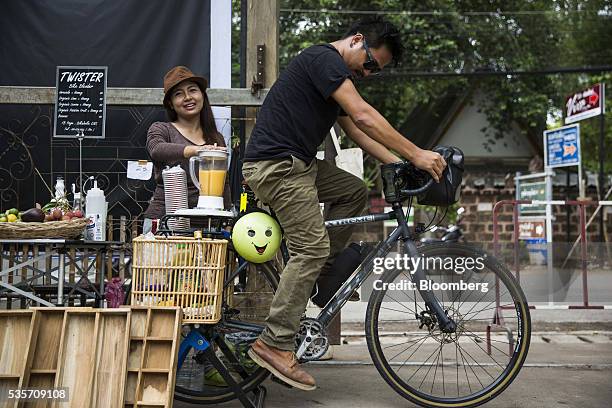 Cyclist powers a blender by pedaling a bicycle at a juice stall in a farmer's market in Chiang Mai, Thailand, on Sunday, May 29, 2016. Thailand's...