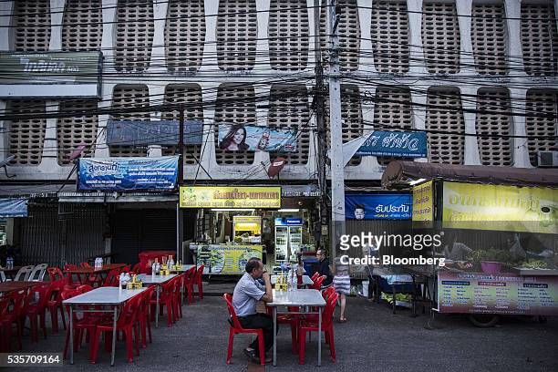 Man sits at an outdoor restaurant table in the North Gate market in Chiang Mai, Thailand, on Sunday, May 29, 2016. Thailand's gross domestic product...
