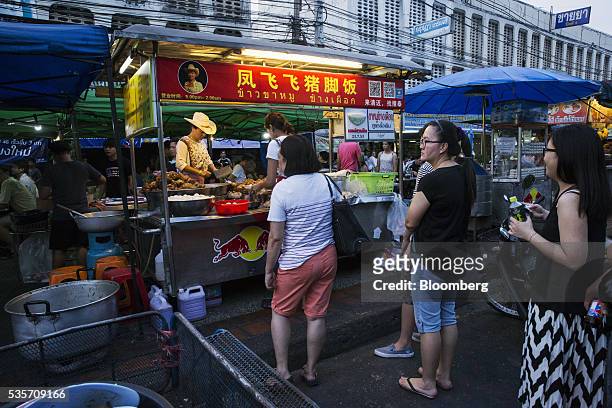 Customers wait in line at a food stall in the North Gate market in Chiang Mai, Thailand, on Sunday, May 29, 2016. Thailand's gross domestic product...