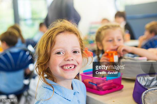 smiling girl missing a tooth with a healthy lunch - education stock pictures, royalty-free photos & images