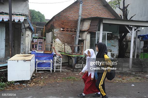 Students walk pass trough the houses which left by the owner near the Lapindo mudflow area during the tenth anniversary of the Lapindo mudflow...