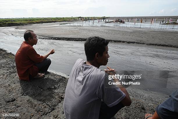 Lapindo mudflow victims pray and sow flowers during the tenth anniversary of the Lapindo mudflow eruption on May 30, 2016 in Sidoarjo, East Java,...