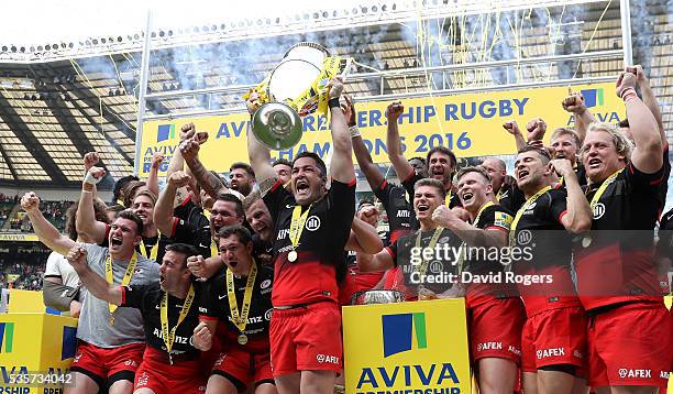 Brad Barritt, the Saracens captain, raises the Aviva Premiership trophy after their victory during the Aviva Premiership final match between Saracens...