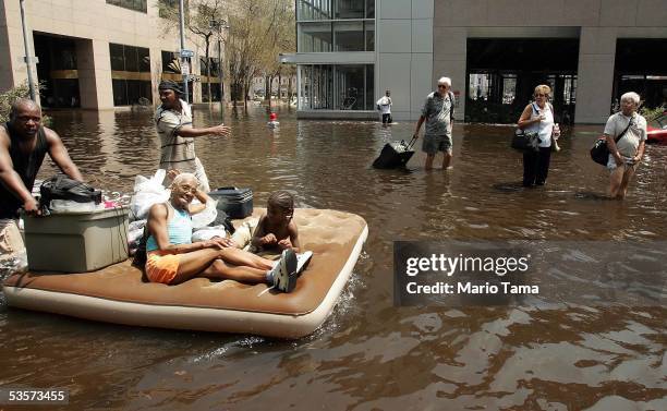 People leave the Superdome in the hopes of catching a ride out of town after Hurricane Katrina August 31, 2005 in New Orleans. Thousands of others...