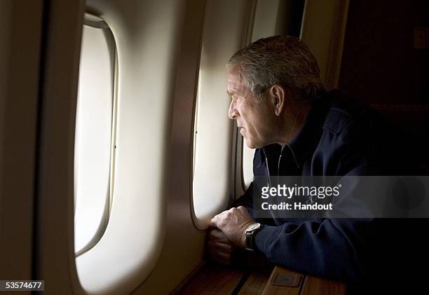 In this handout photo provided by the White House, U.S. President George W. Bush looks out over devastation from Hurricane Katrina as he heads back...