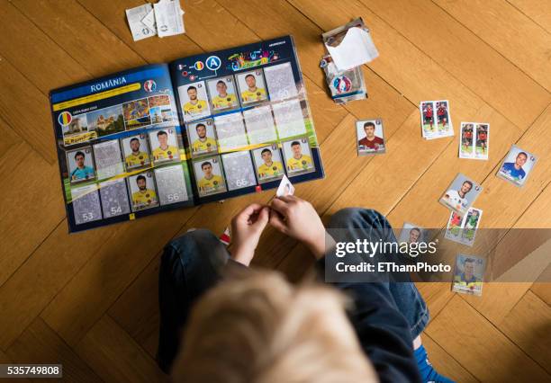 8 year old boy pasting soccer trading cards into his scrapbook - trading card stock pictures, royalty-free photos & images