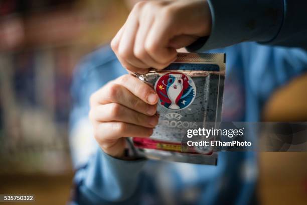 8 year old boy pasting soccer trading cards into his scrapbook - pão de queijo prensado imagens e fotografias de stock