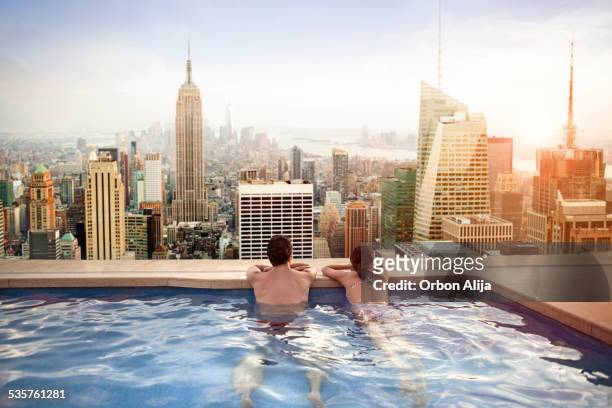 couple relaxing on hotel rooftop - new york stockfoto's en -beelden
