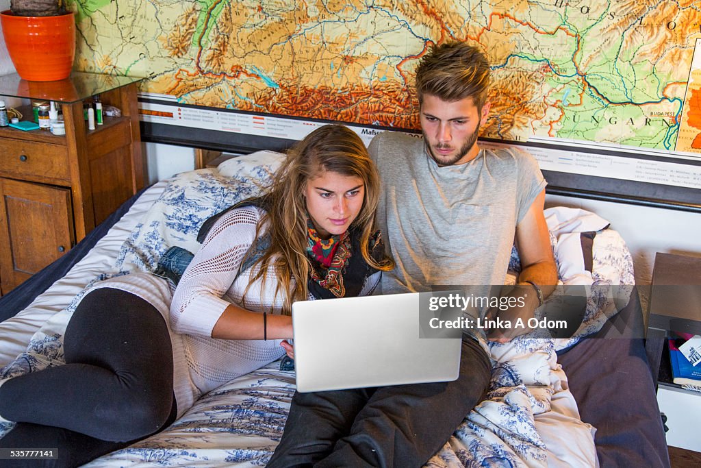 Couple on bed with laptop