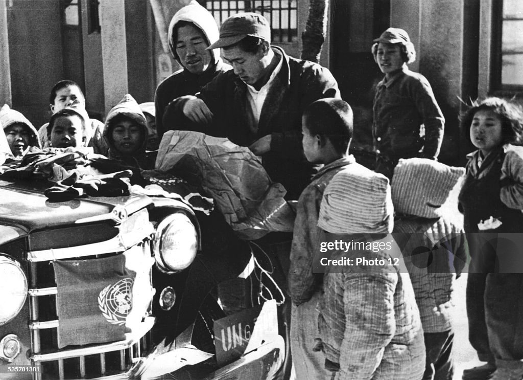 Korean war, orphans gather around a United Nations jeep, to examine the contents of parcels send by foreign children(1950-1953)