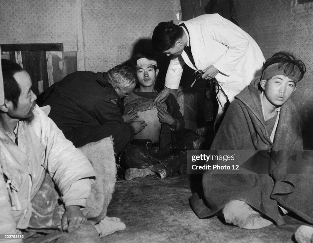 Refugees from Koje island. Doctor Henri Meyer examines a refugee suspected to have contracted typhus